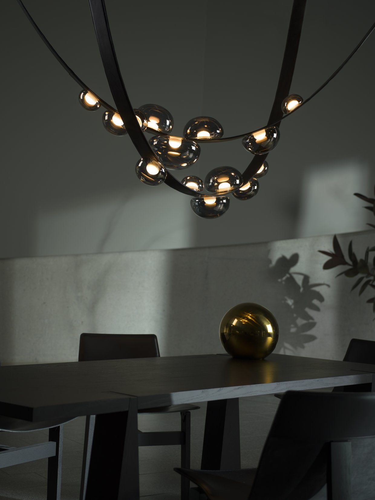 Bomma Dew Drops chandelier over a dark dining table